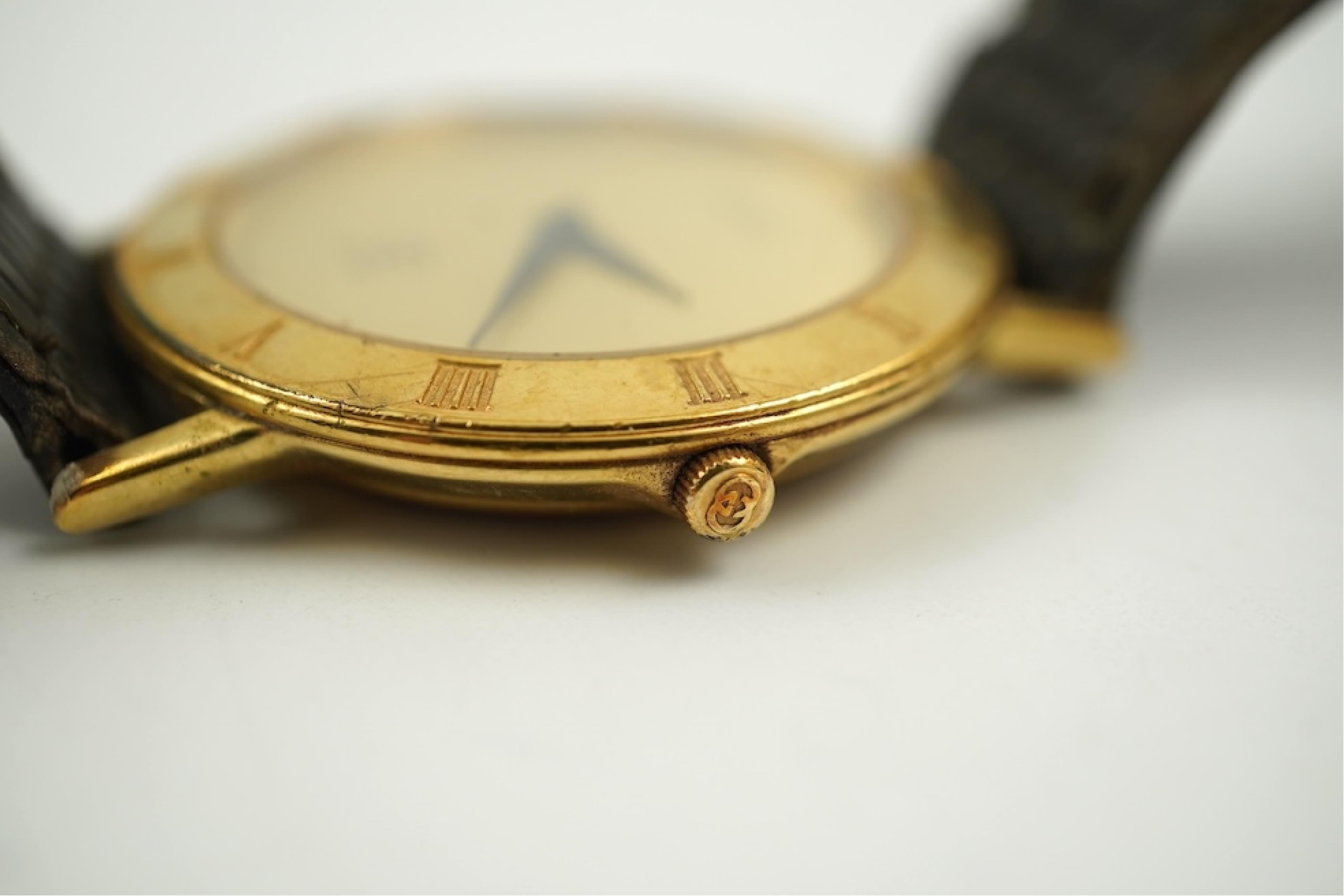 A gentleman's recent 18k gold electro-plated Raymond Weil quartz dress wrist watch, case diameter 33mm and a similar Gucci quartz dress wrist watch.